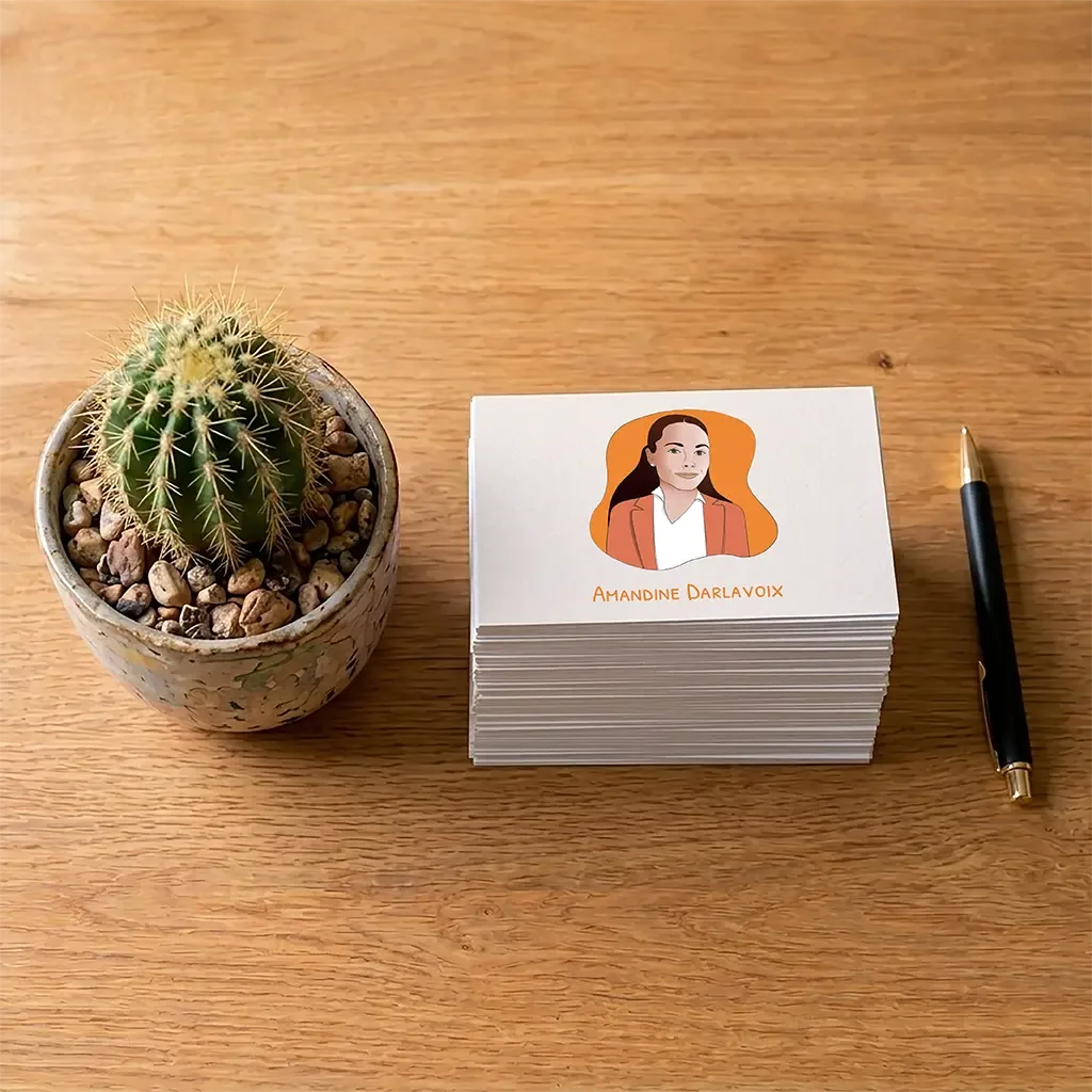 Carte de visite d'Amandine Darlavoix avec son avatar illustré, posée sur un bureau