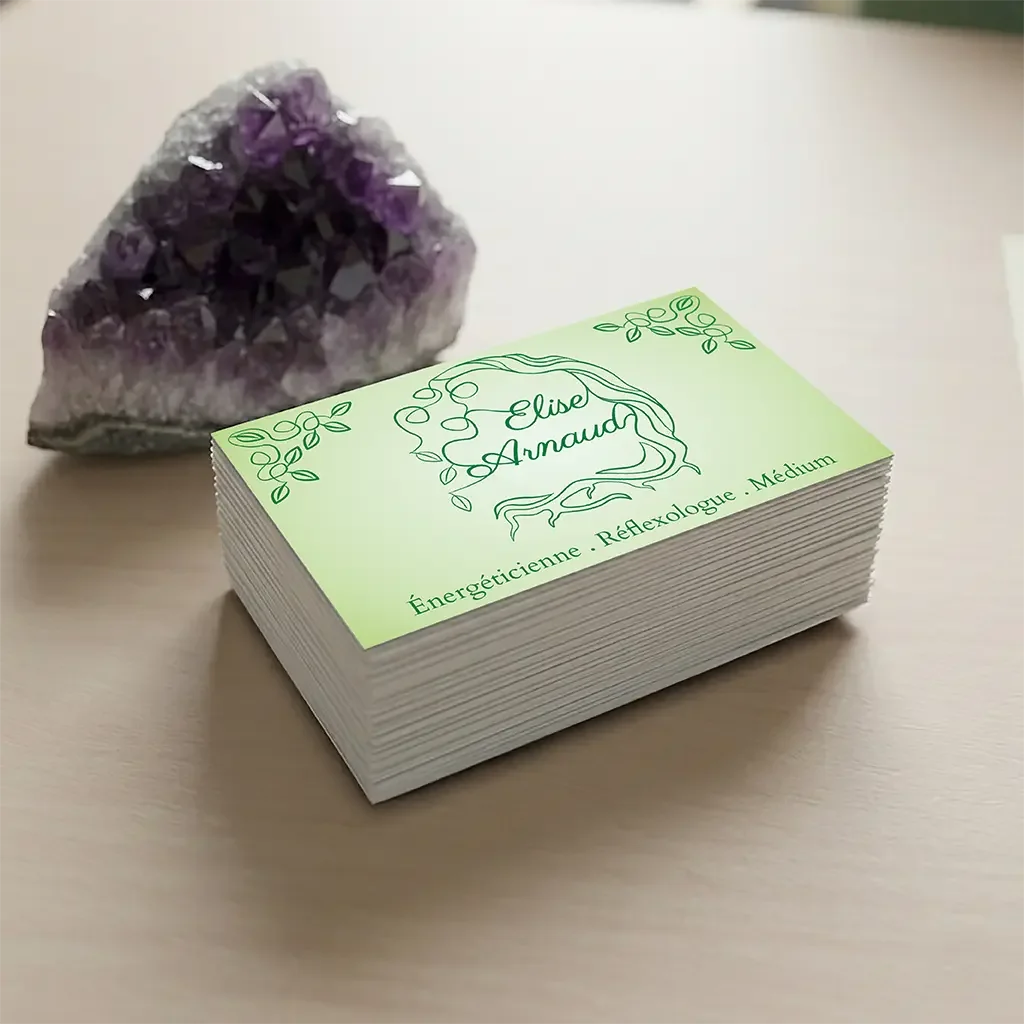 Carte de visite d'Elise Arnaud avec son logo végétal vert, posée à côté d'une améthyste